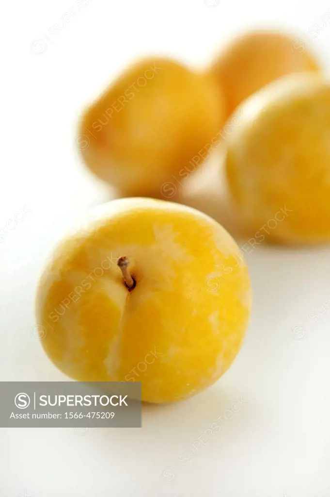 Close up of yellow Mirabelles on white background