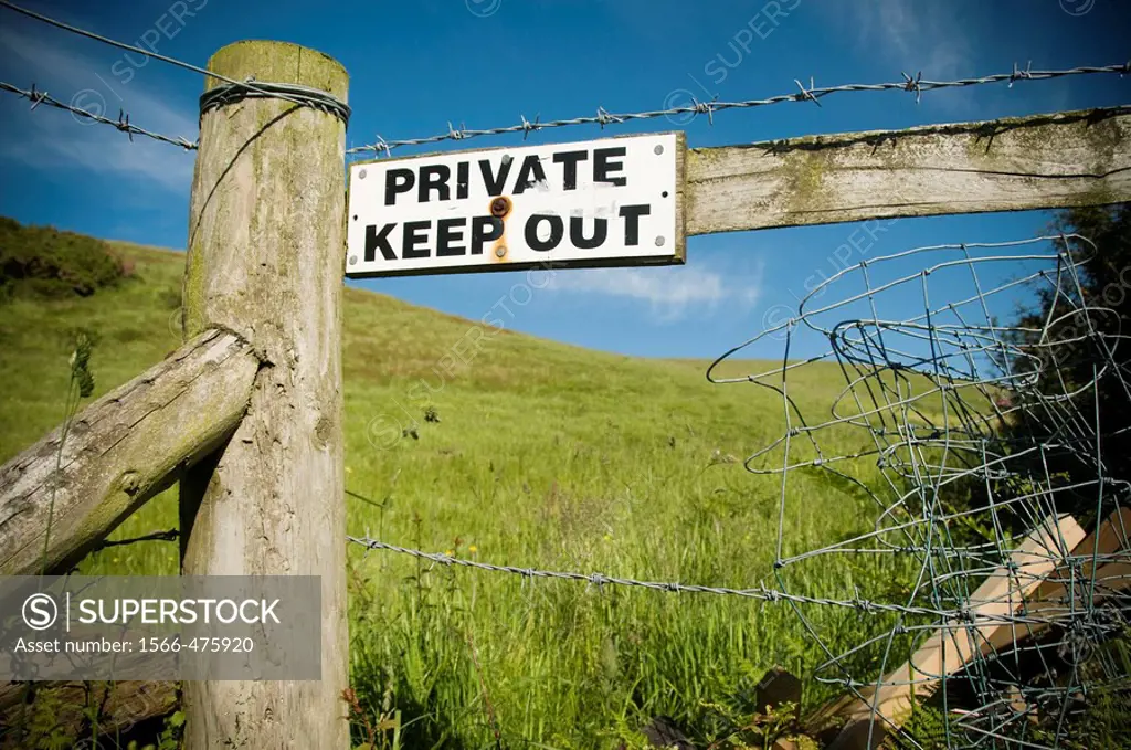 ´Private Keep Out´ sign on fence around a field