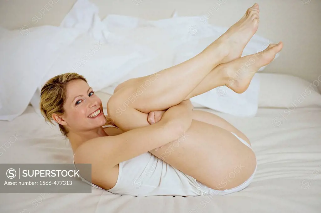 Woman on the bed happy with legs up