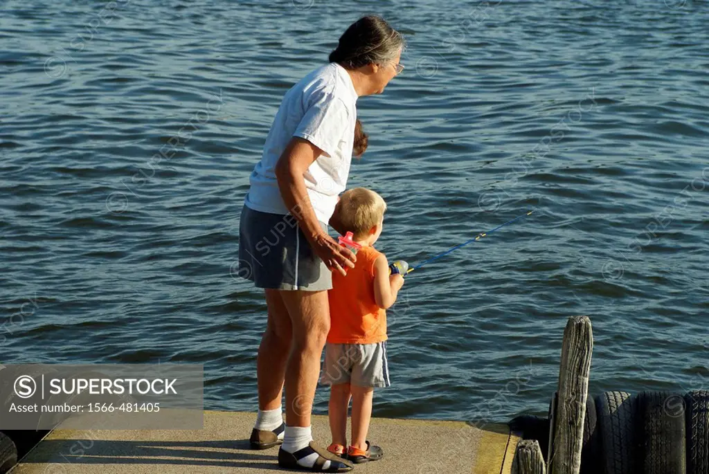 Learning to fish on a summer day with supervision by the boy´s Grandmother.