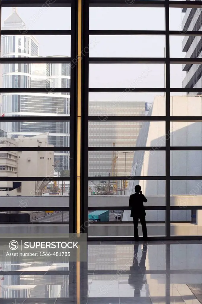 Silhouette of a Chinese man having a telephone conversation while standing in the lobby of an office building, Hong Kong, China, Southeast Asia