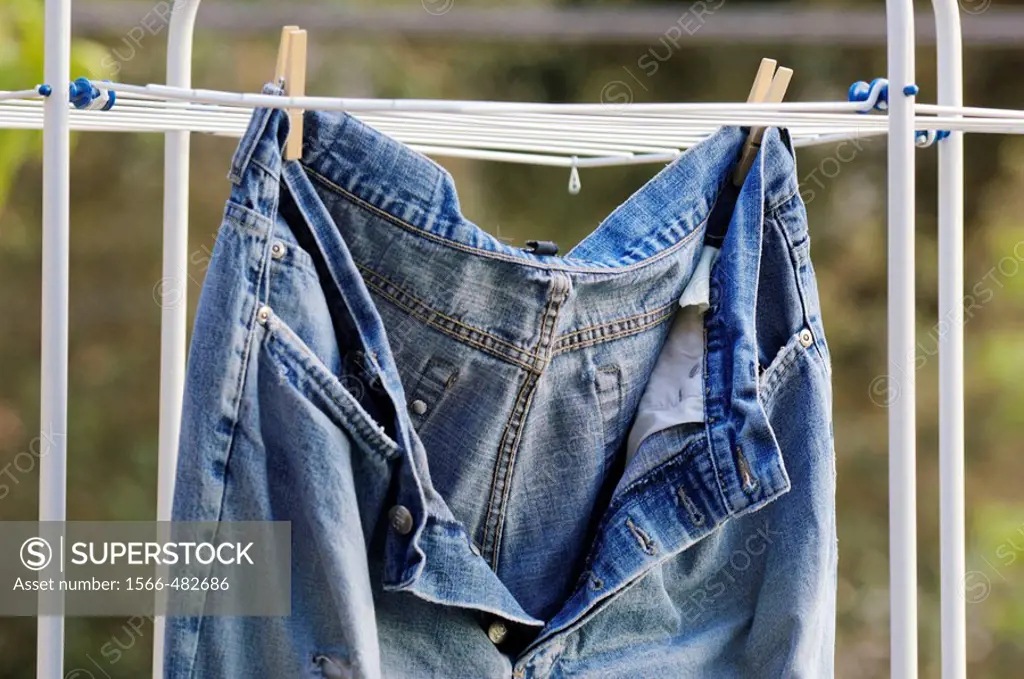 Old, ripped, well worn jeans trousers put to dry
