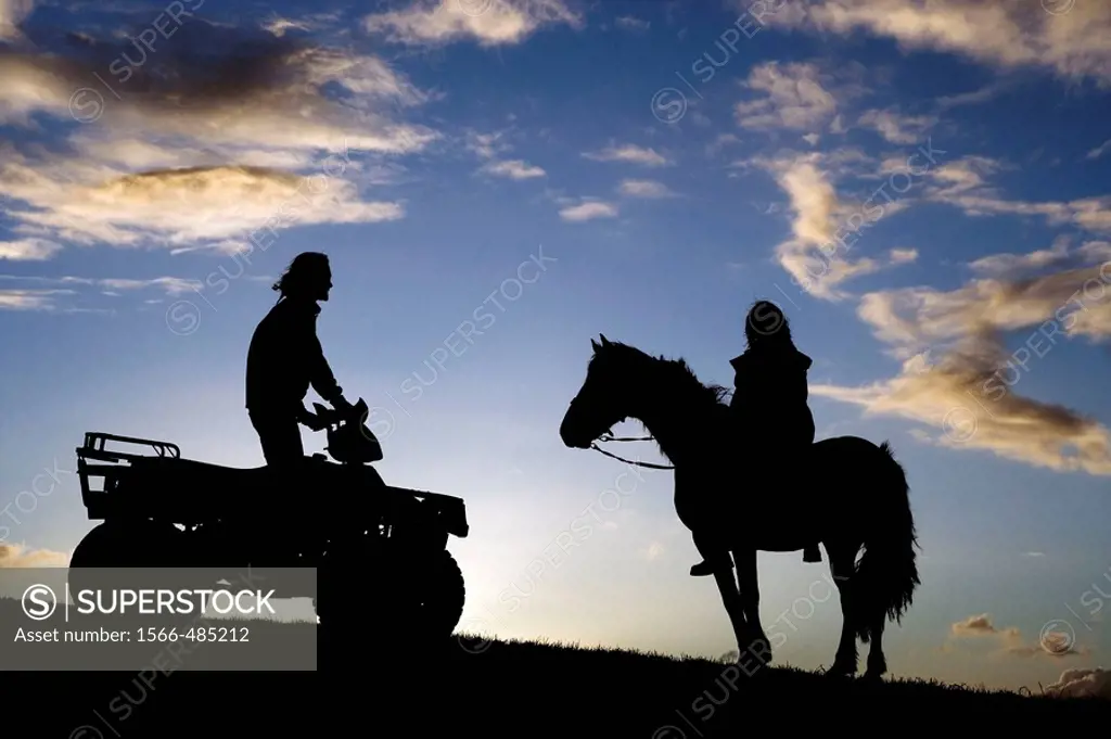 Quad bike and horse rider on ridge