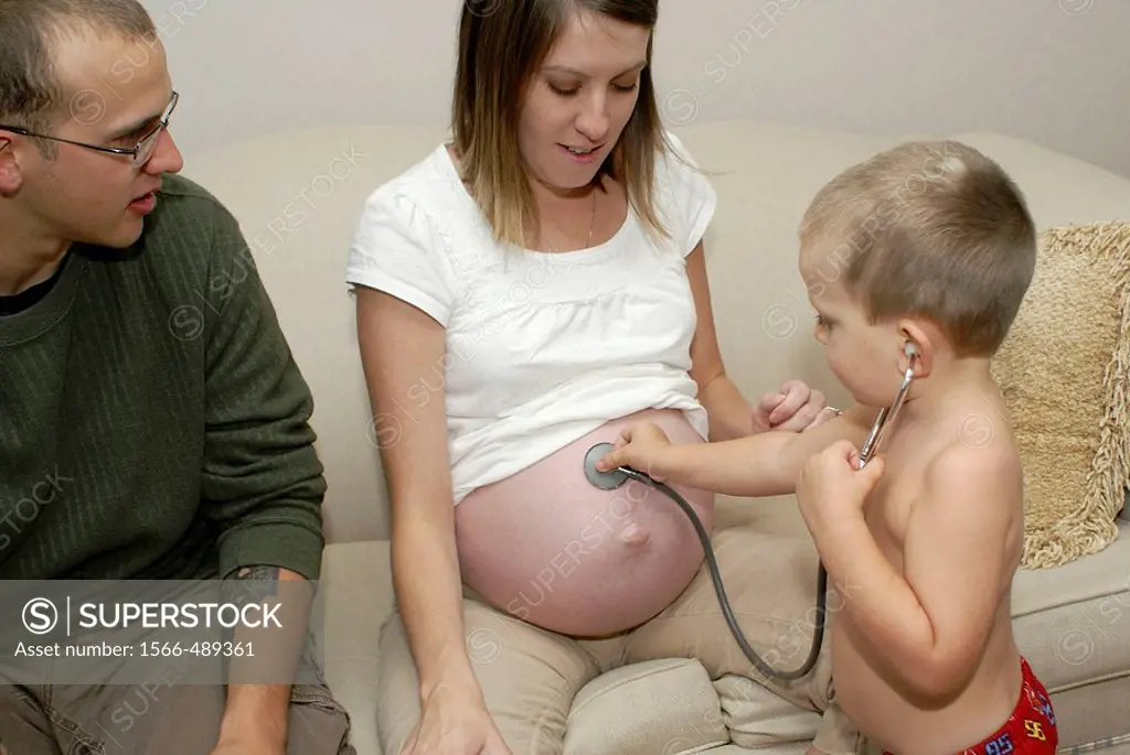 With a stethoscope this youngster is trying to hear the heartbeat of his new brother still inside the mommy