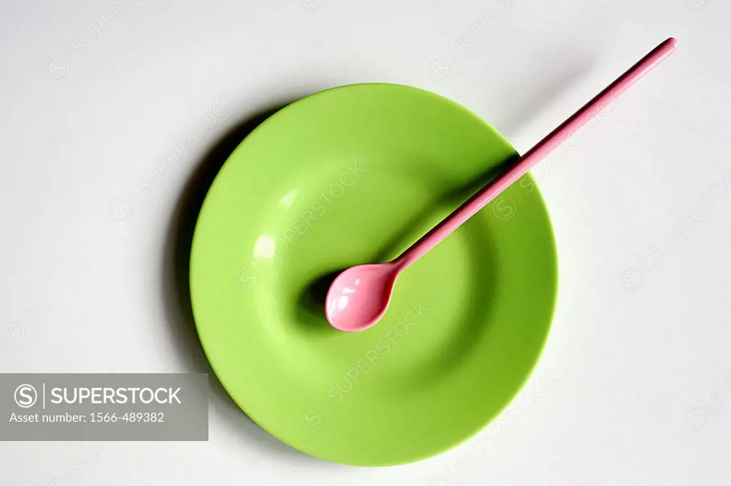 zenithal view of a plastic color plate and spoon on white background