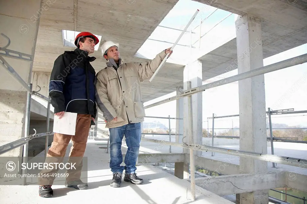 Architect and construction worker, personal protective equipment, housing construction, concrete skeleton