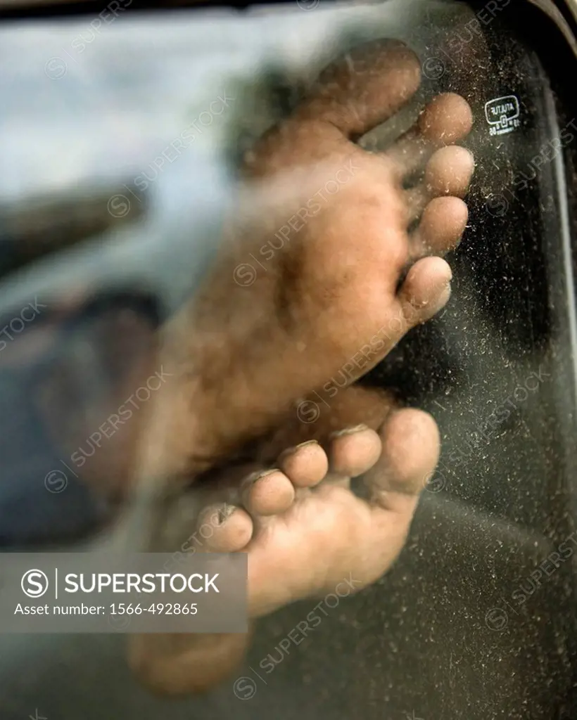 close up colorful shot of a cab drivers feet in car window taking a nap..