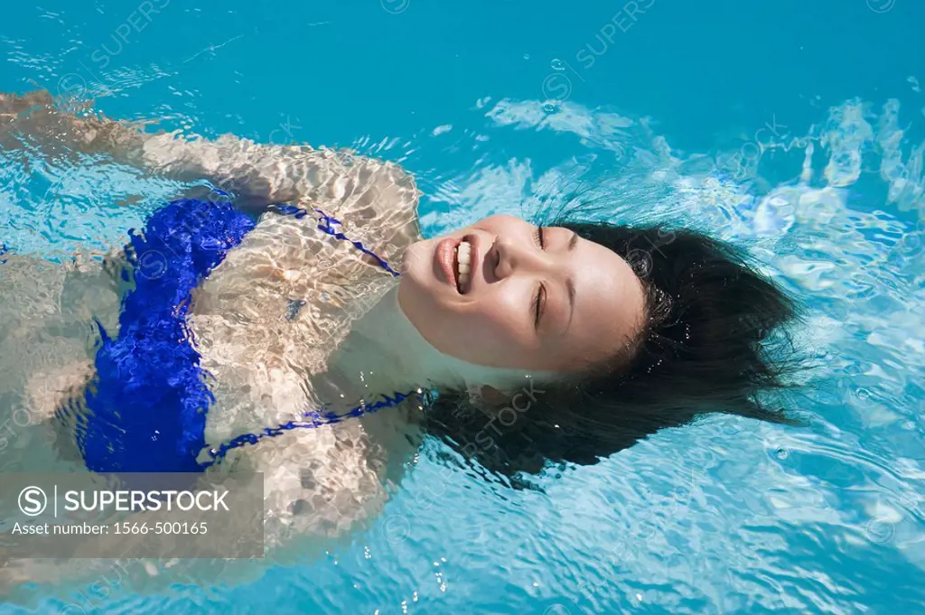 A young Japanese woman swimming in a pool.