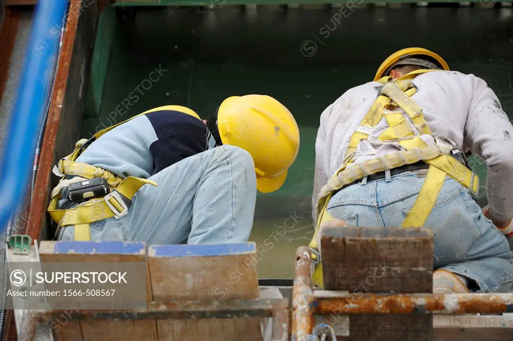 Two construction workers working on scaffolding