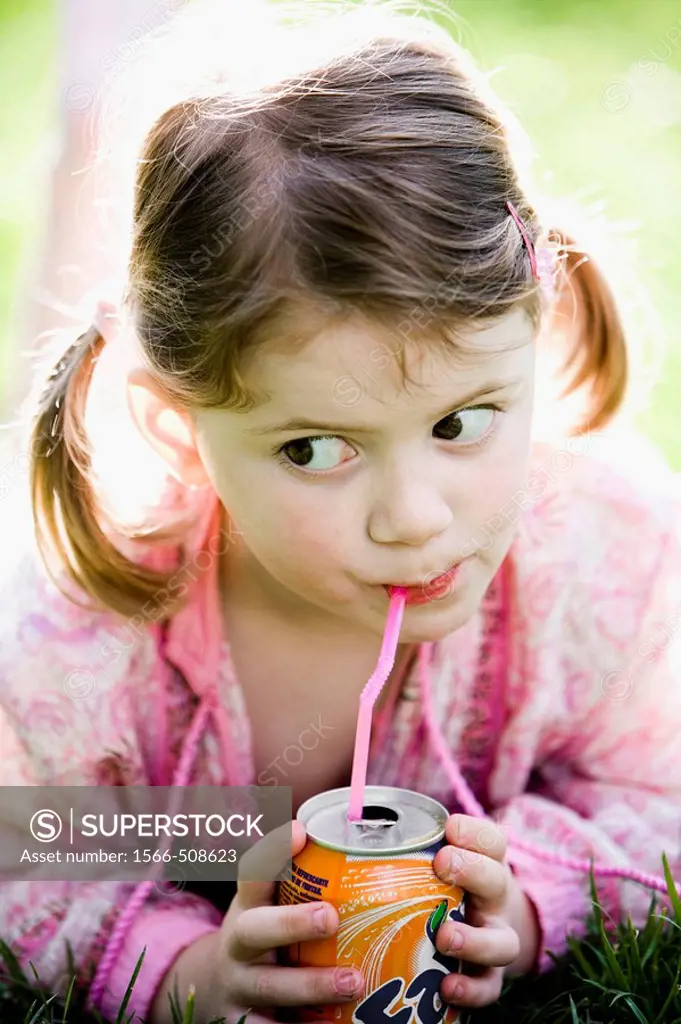 Little girl drinking soda with a straw