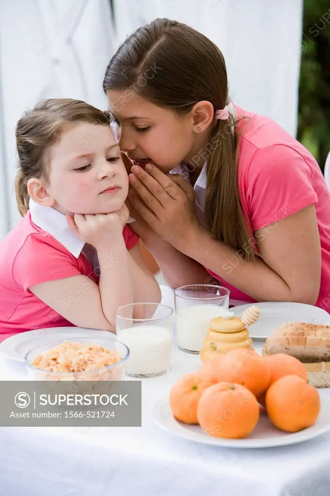 Girl whispering to her sister