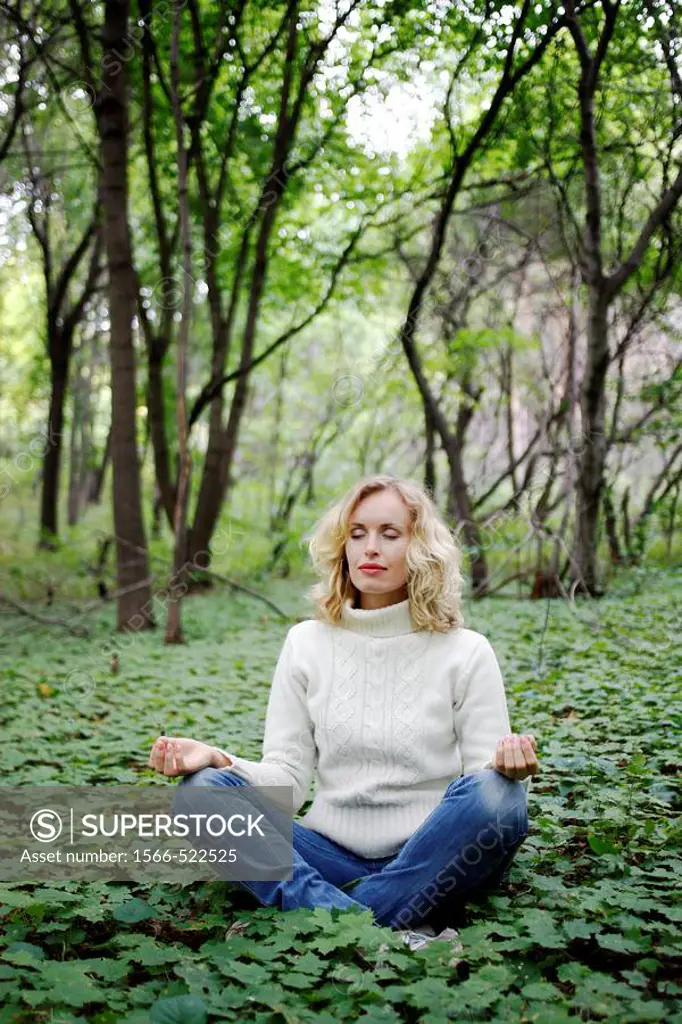 Young woman doing yoga in a russian forest, Molodeskiy Kurgan National Park, Samara Region, Russian Federation