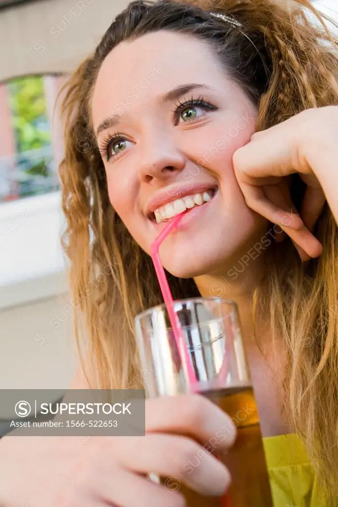 Young woman drinking juice through straw