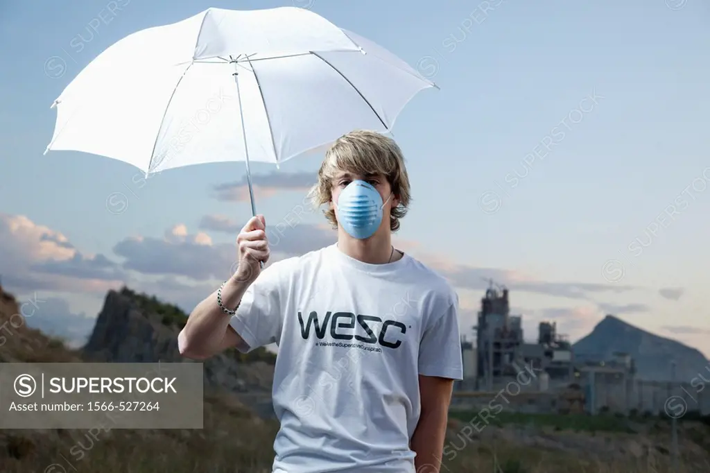 Man with umbrella and contamination mask near a cement works