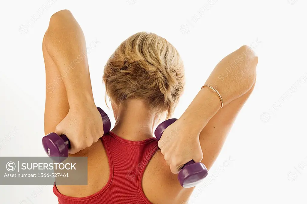 Young woman, blonde, exercising with weights in the gym to get fit.