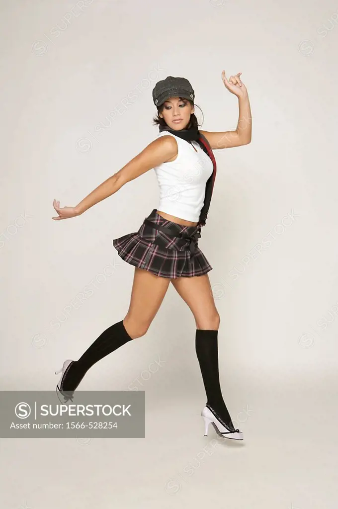 Trendy model jumping in a studio setting