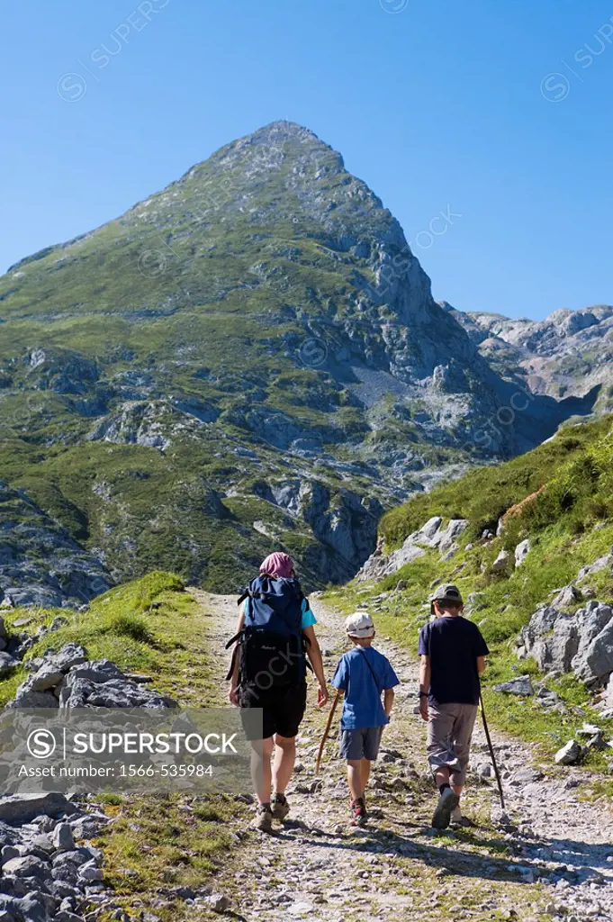 Family hiking in the Ándara massif, mountain of La Pica de Mancondiu in background. Picos de Europa National Park, Cantabria, Spain