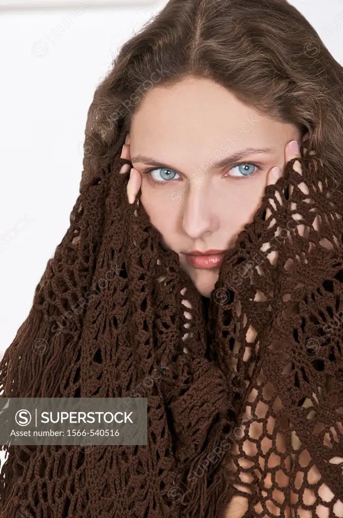 young woman in a brown shawl,holding her temples because of  a headache