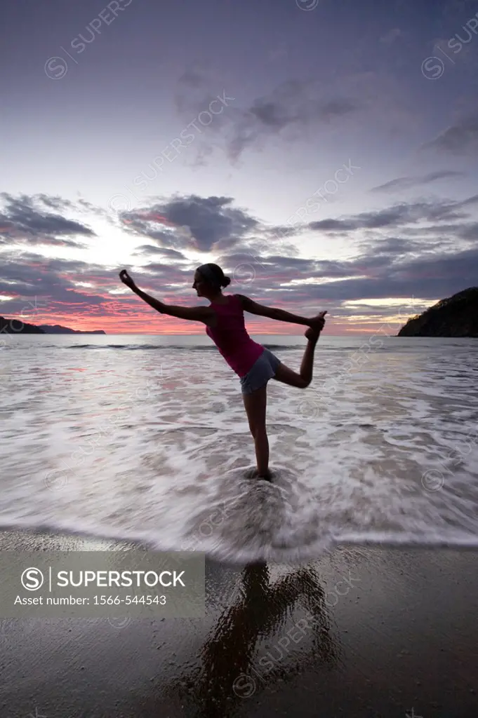 Young woman doing yoga at the beach during sunset in Playas del Coco, Costa Rica