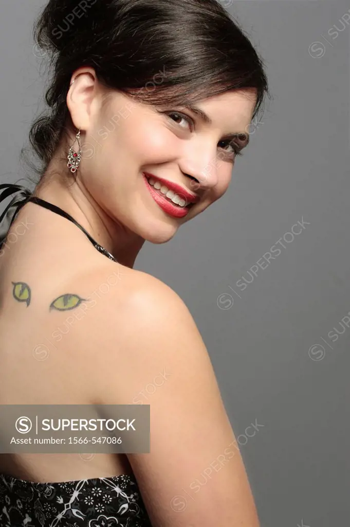 20-something attractive woman with an unusual tattoo of eyes on her back.