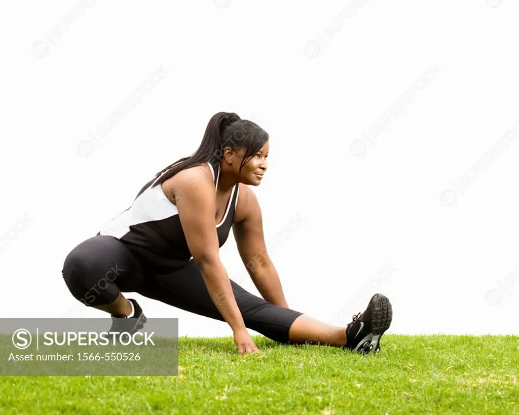 A black plus size female model plus size model in stretching position