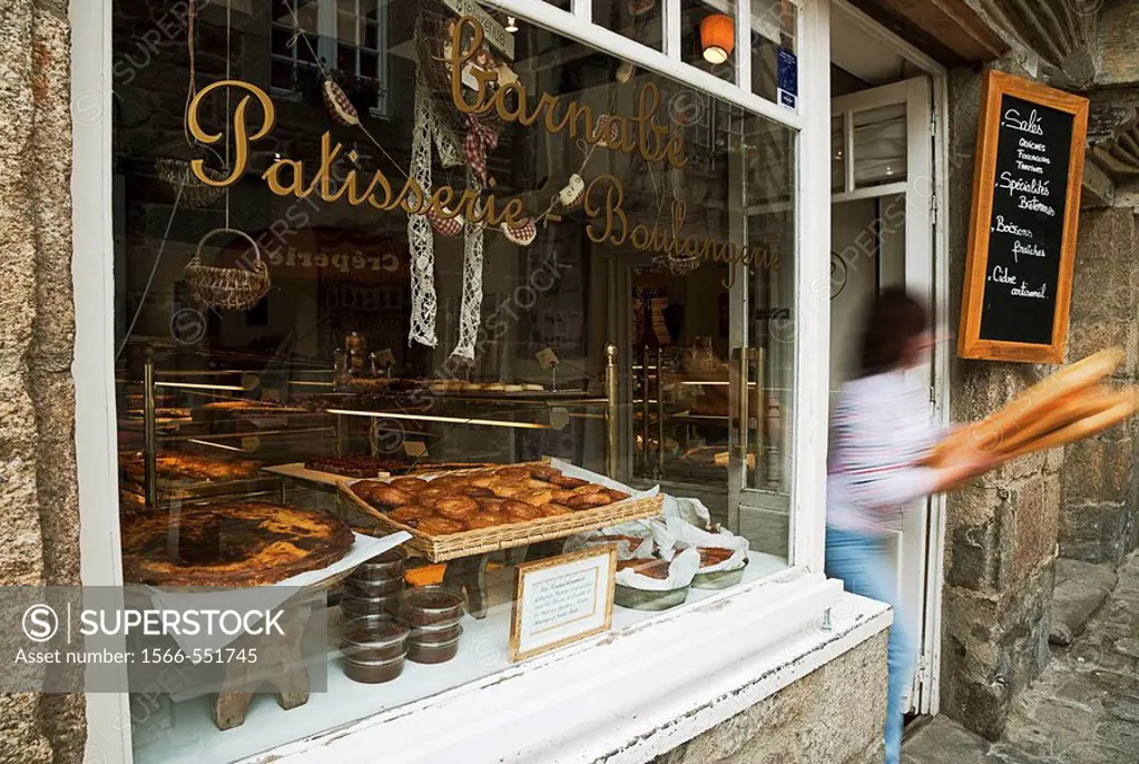 Woman walking with baguettes, pastry shop, bakery, Dinan, Brittany, France