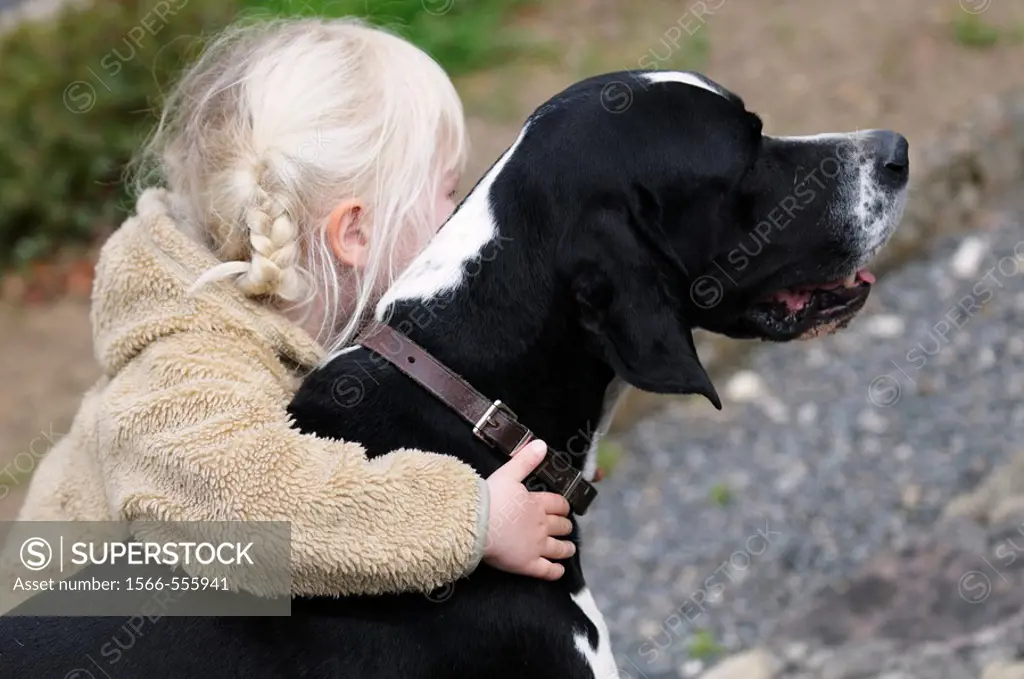 4 year old child hugging her pet dog
