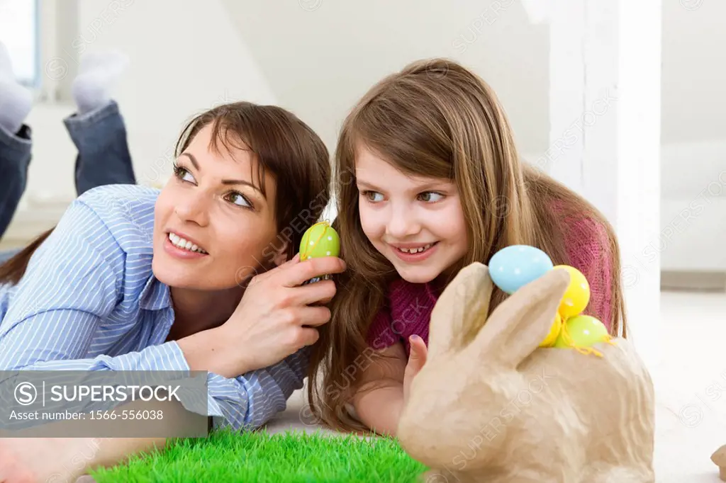 Mother and daughter with Easter eggs and rabbit.