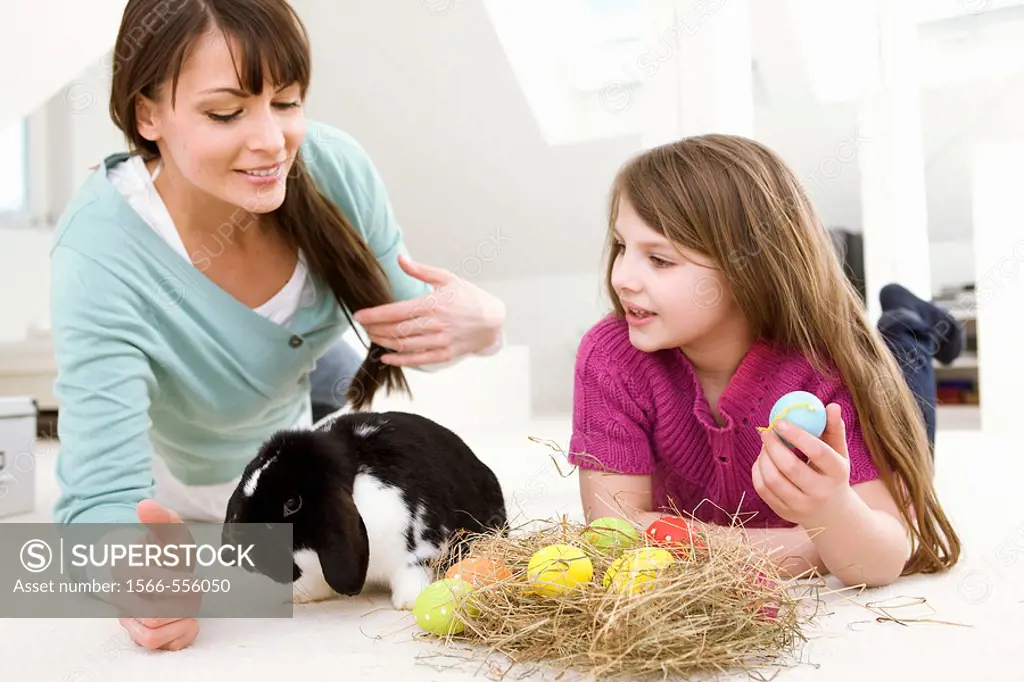Mother and daughter with Easter Eggs and rabbit.