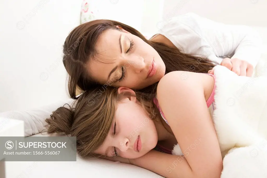 Mother and daughter sleeping in bed.
