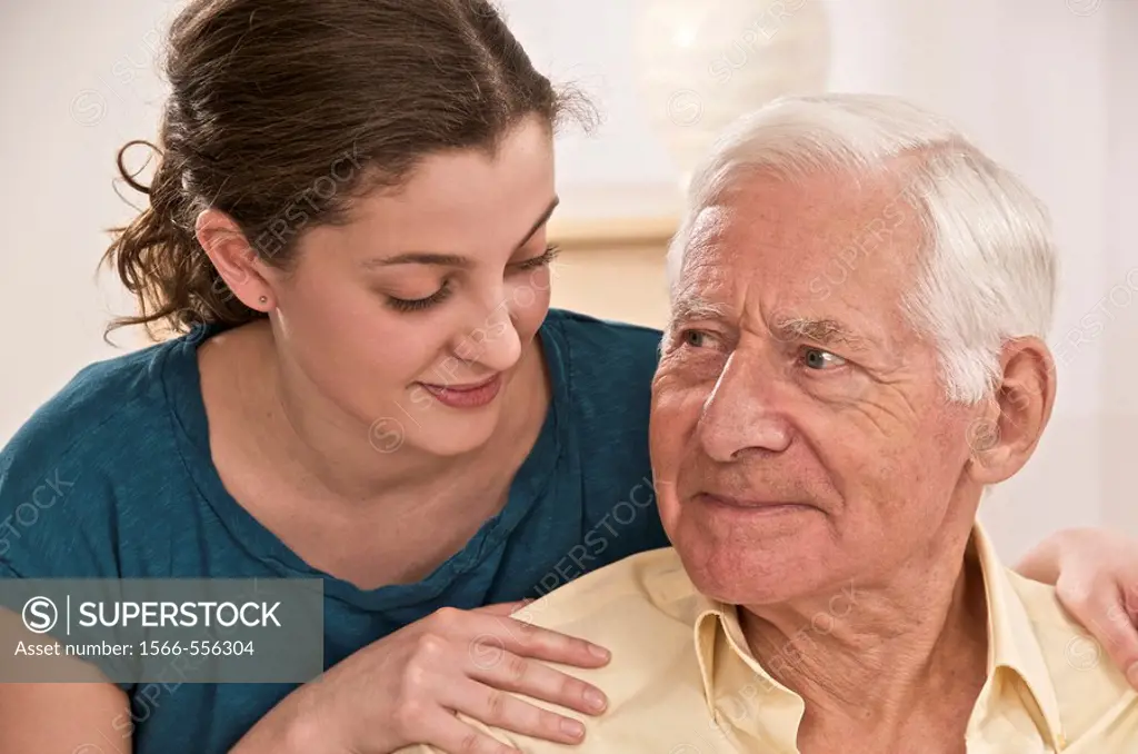 Young woman or grand daughter showing tenderness and reassuring  a senior person or grandfather