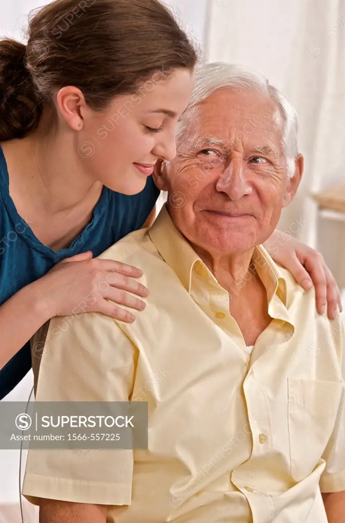 young woman or grand daughter or home help comforting a senior man