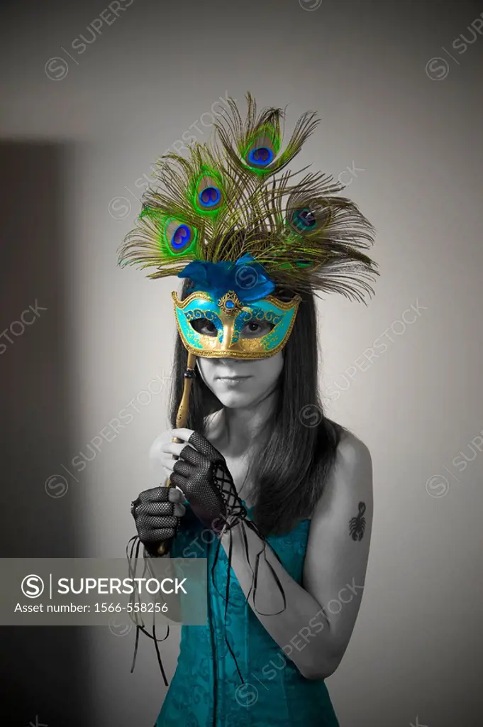 Young woman holding a mask over her face