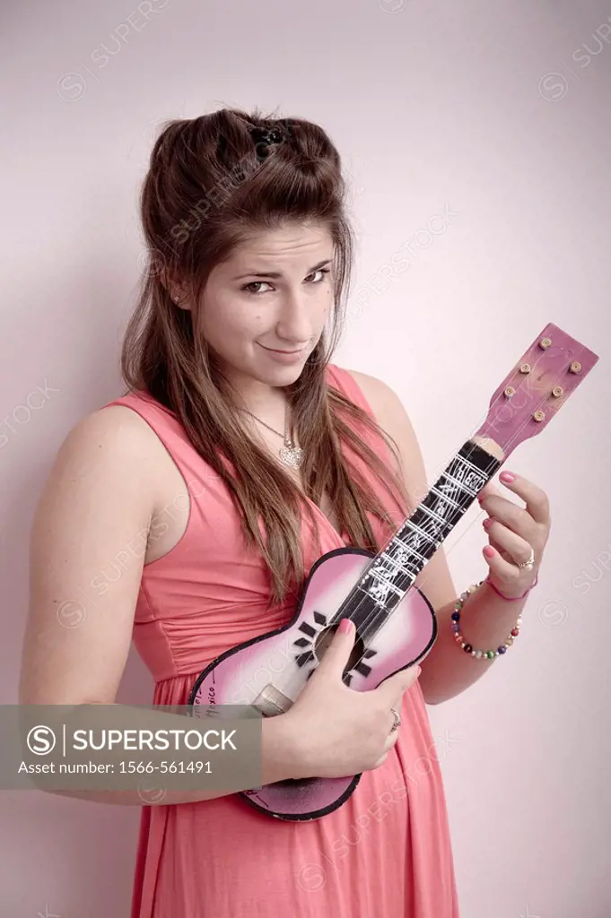 Teen girl playing a ukulele