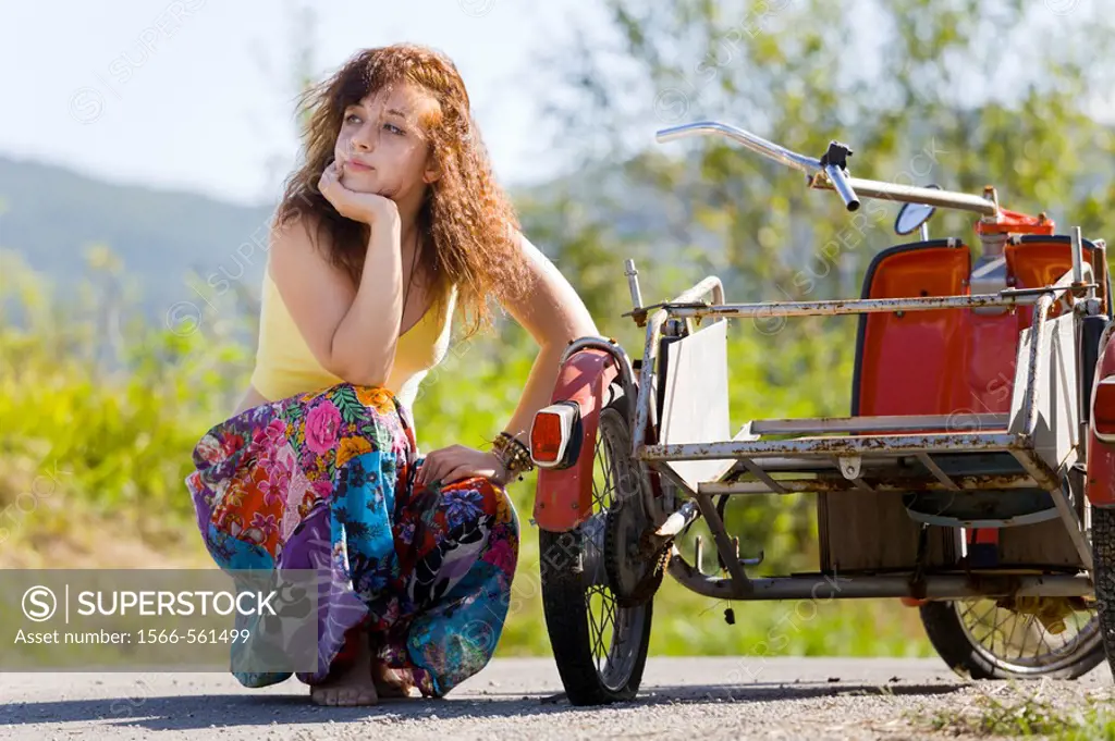 Young woman is waiting for a helping hand with a flat tire