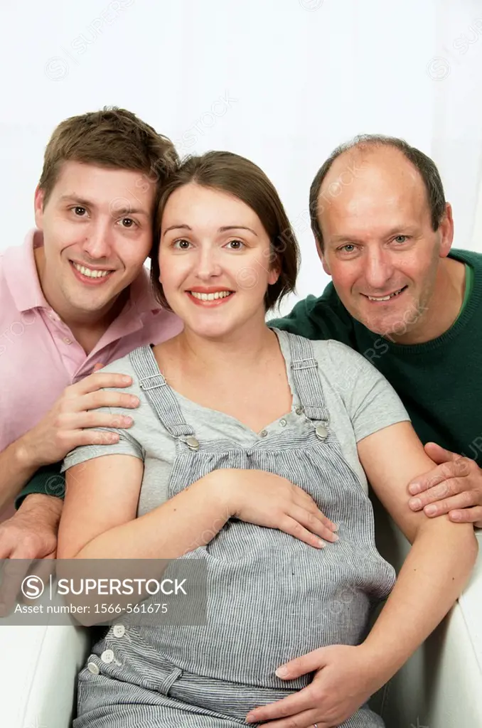 Happy family with Young woman expecting a baby in grey, holding her belly