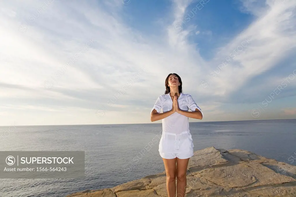 Portrait of a brunette woman doing yoga in a cliff in Ibiza, Balearic Islands