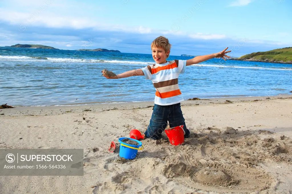 boyl playing on sandy beach, Sutherland, Scotland