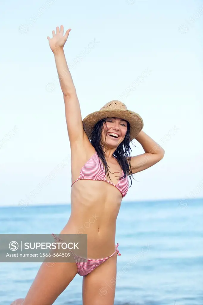Portrait of a content brunette woman at the beach in Ibiza, Balearic Island