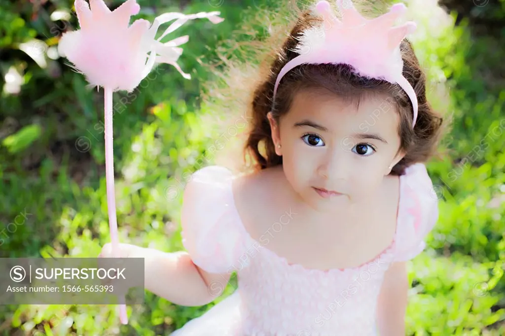 Little girl playing dress up as a princess.