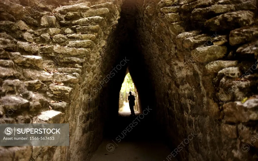A tourist walks under a covered pathway in the Mayan ruins of Becan in Campeche State in Mexico´s Yucatan peninsula, Mexico.