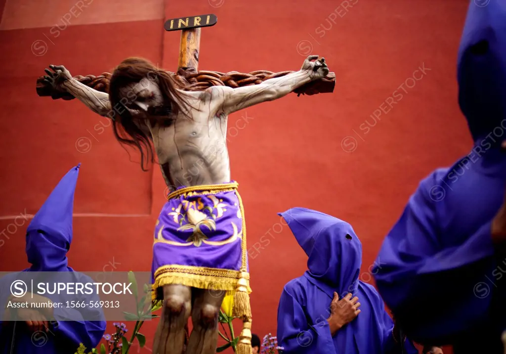 A statue of a crucified Jesus Christ is surrounded by penitents during a holy week procession in Oaxaca, Mexico.