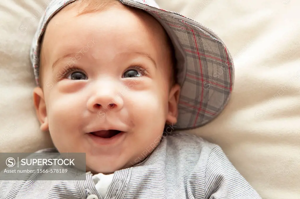 Studio shot of baby boy wearing hat and smiling