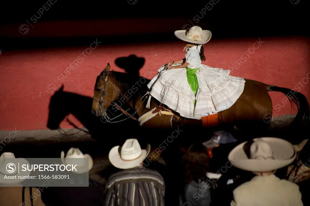 Spectators watch a Mexican amazona ride her horse at the National Charro Championship in Pachuca, Hidalgo State, Mexico. Escaramuzas are similar to US...