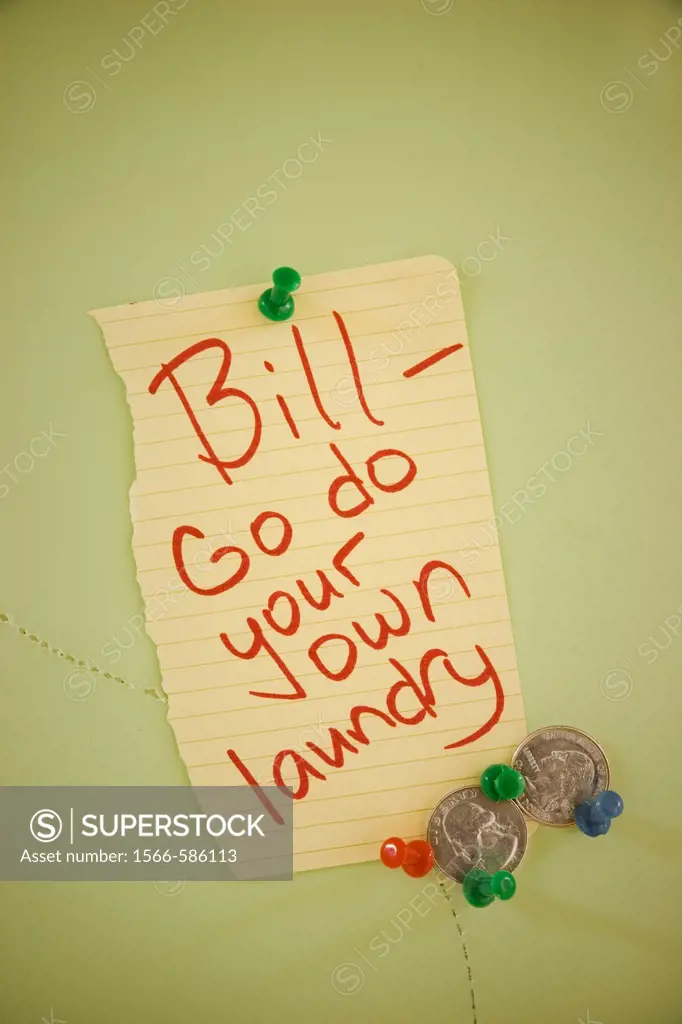 Two American quarters tacked to a bulletin board next to a note reading, ´Bill, go do your own laundry´