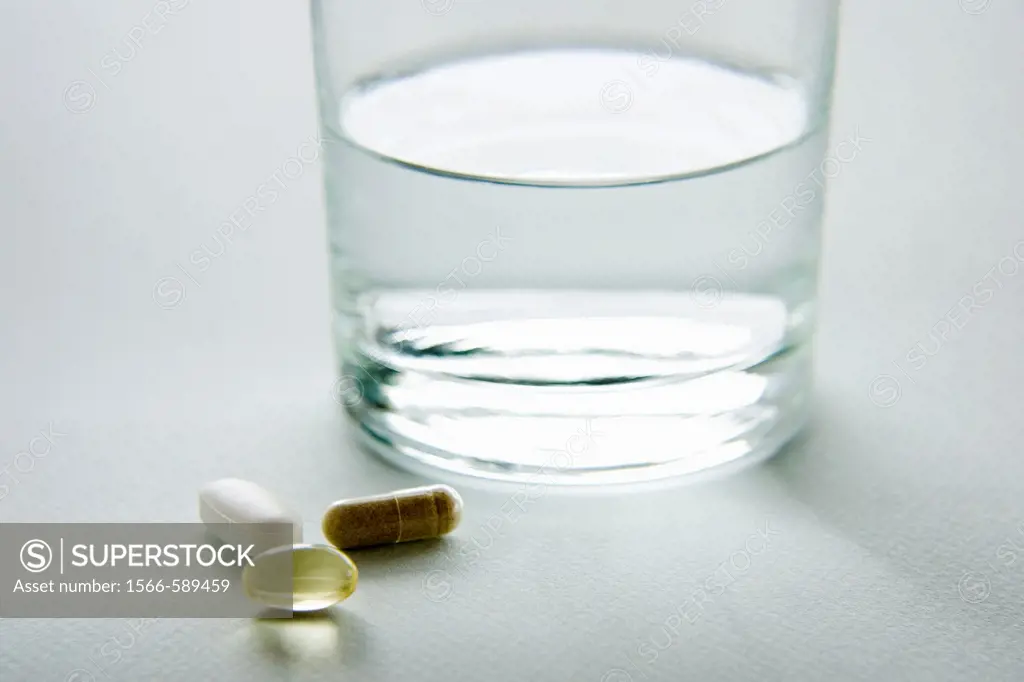Various vitamins with a glass of water