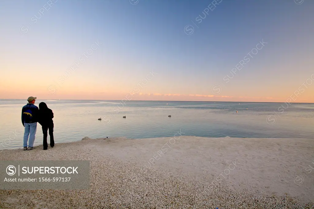 A couple watches the sunset over the Atlantic ocean off Islamorada in the Florida Keys