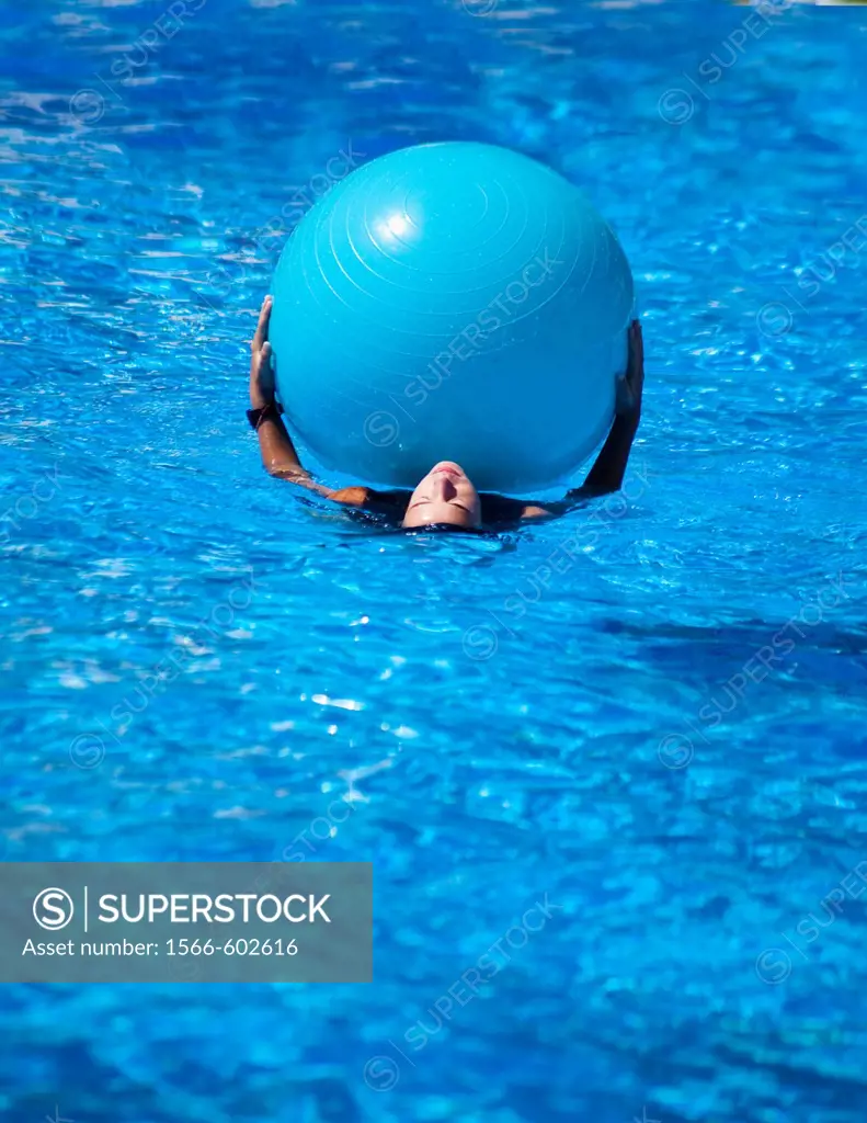 girl swimming with ball