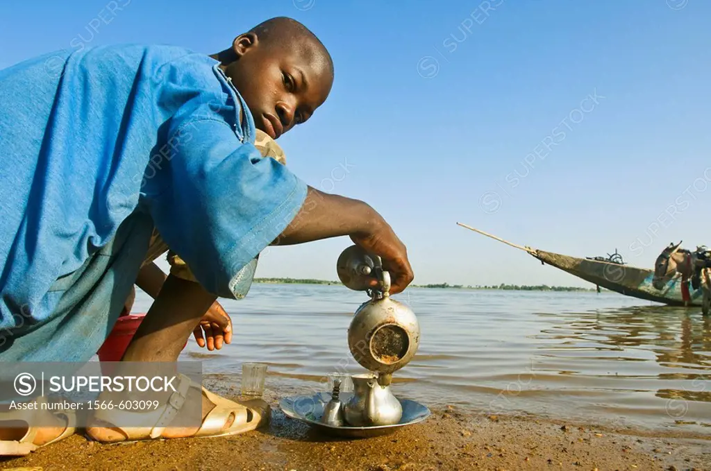 Young man preparing tea by Niger River, Segou, Mali