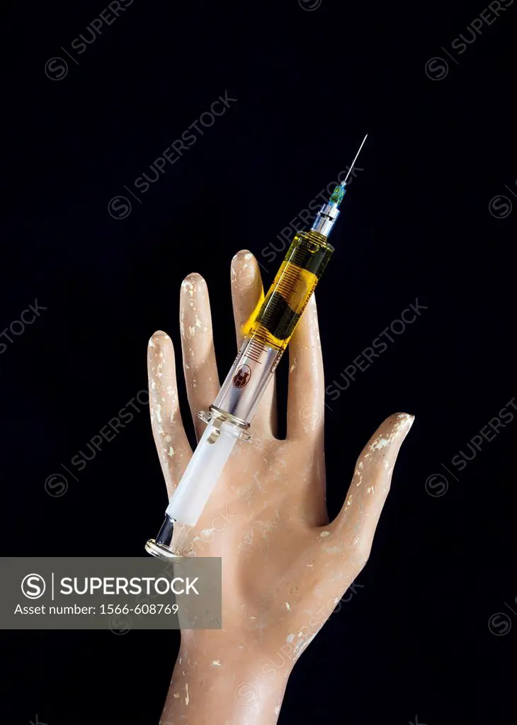 Dummy hand with hypodermic needle in palm